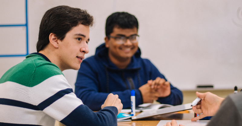 Two teenage boys sitting at a table.